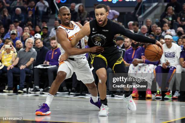 Stephen Curry of the Golden State Warriors is guarded by Chris Paul of the Phoenix Suns at Chase Center on March 13, 2023 in San Francisco,...