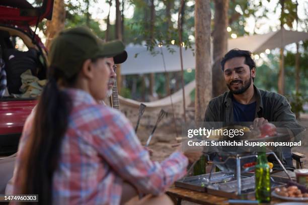 a friends tourist drinking and playing guitar together with happiness in summer. - indian rural people playing with tourists stock-fotos und bilder