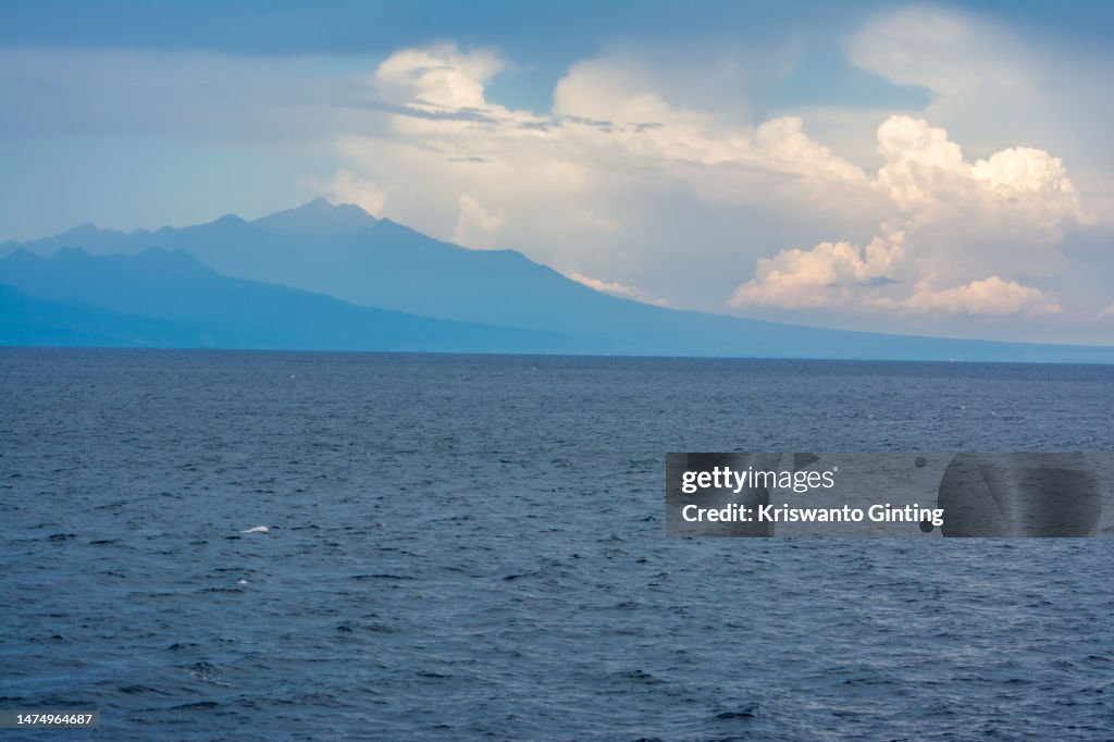 Mountains gradation with blue Sky over the Blue Ocean