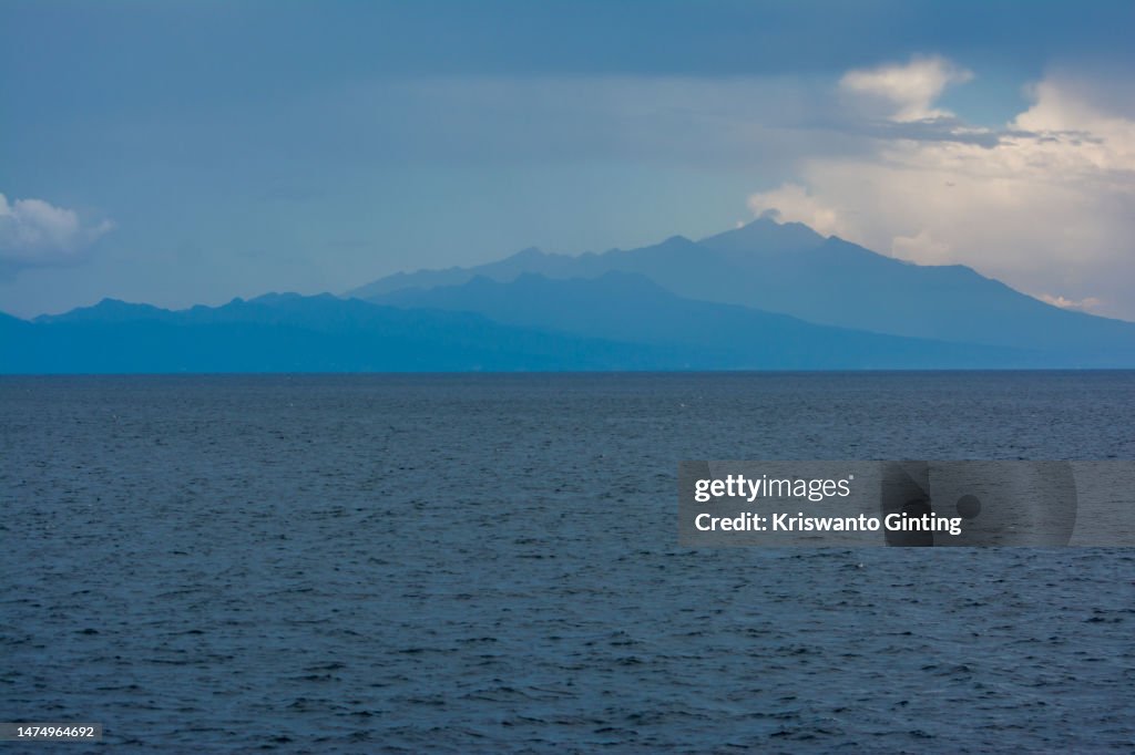 Mountains gradation with blue Sky over the Blue Ocean