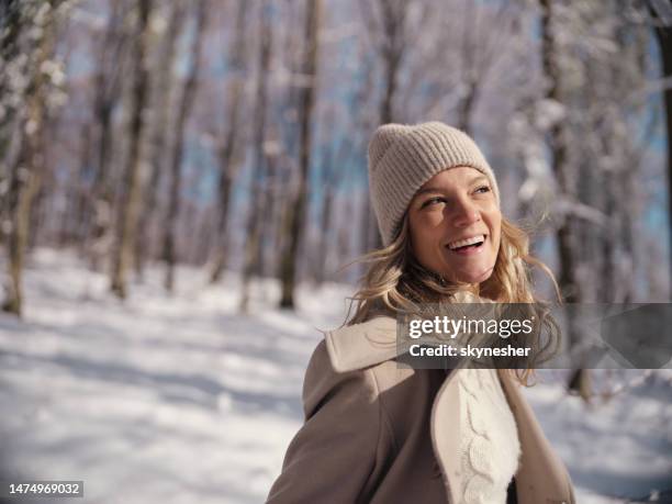 mujer feliz disfrutando durante el día de invierno en el bosque. - mujeres de mediana edad fotografías e imágenes de stock