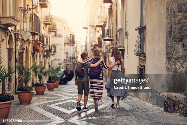 mère et adolescents visitant la belle ville italienne de cefalu, en sicile - escapade urbaine photos et images de collection