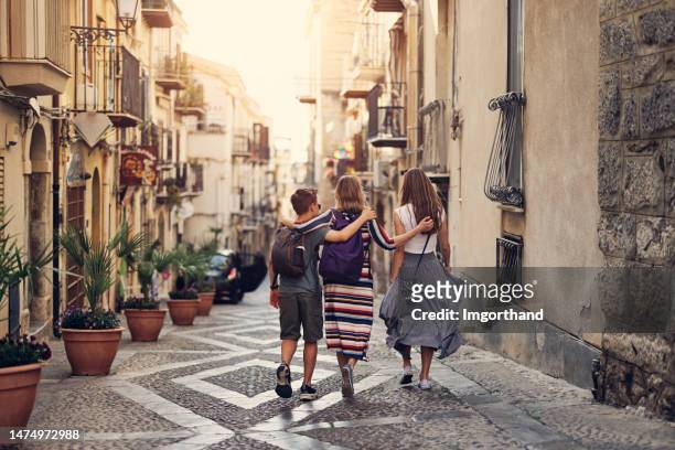 madre e bambini adolescenti che visitano bella città italiana di cefalù, sicilia - centro storico foto e immagini stock