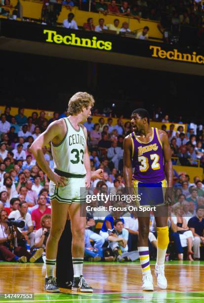 Larry Bird of the Boston Celtics and Magic Johnson of the Los Angeles Lakers looks on during the 1984 NBA Finals June 1984 at The Boston Garden in...