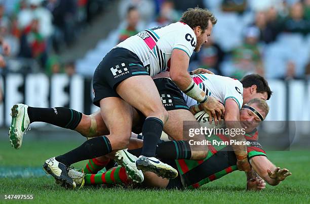 Michael Croker of the Rabbitohs is tackled during the round 17 NRL match between the South Sydney Rabbitohs and the Penrith Panthers at ANZ Stadium...