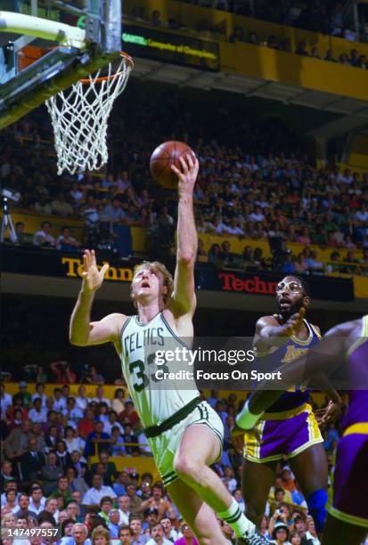 Larry Bird of the Boston Celtics lays the ball up in front of James Worthy of the Los Angeles Lakers during the NBA Finals June 1985 at The Boston...