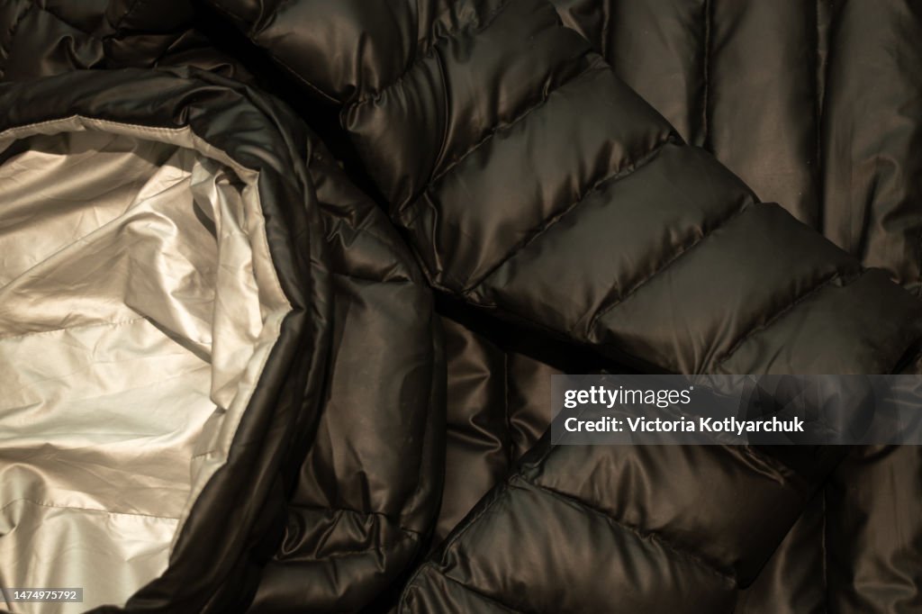 Black down jacket winter puffed as a background close up