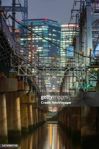 skyscrapers and pylons futuristic neon night cityscape osaka japan - railway bridge stockfoto's en -beelden