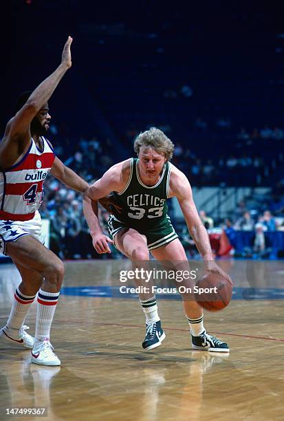 Larry Bird of the Boston Celtics drives on Greg Ballard of the Washington Bullets during an NBA basketball game circa 1985 at the Capital Center in...