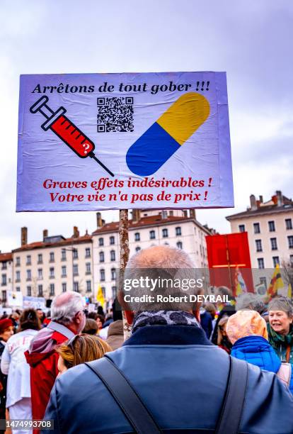 Pancarte "ARRÊTONS DE TOUT GOBER" avec les dessins d'une seringue et d'une gélule lors d'une manifestation pour la réintégration des employés non...