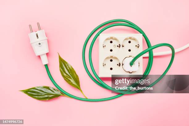green power cable with plug and multiple socket on pink background, green energy - steckerleiste stock-fotos und bilder