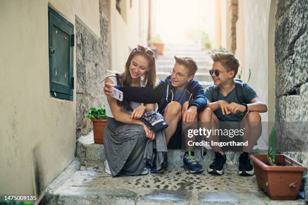 teenage tourists sightseeing beautiful sicilian town of cefalu - boys and girls town stock pictures, royalty-free photos & images