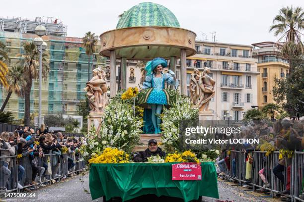 Jeune femme sur un char fleuri sur le thème du jardin lors du défilé des 150 ans du carnaval de Nice le 18 février 2023.
