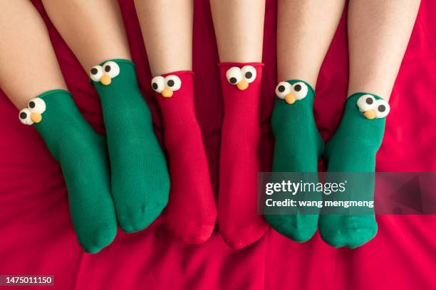 three pairs of feet wearing cartoon socks - comic augen stock-fotos und bilder