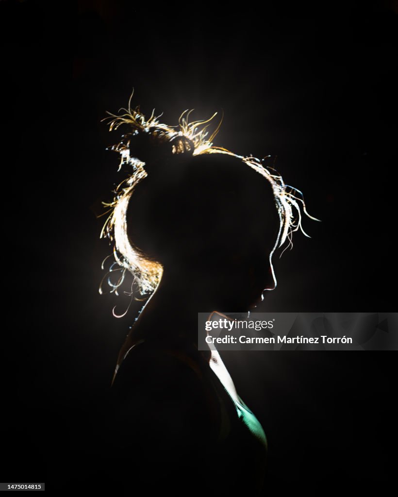 Silhouette of young woman side view.
