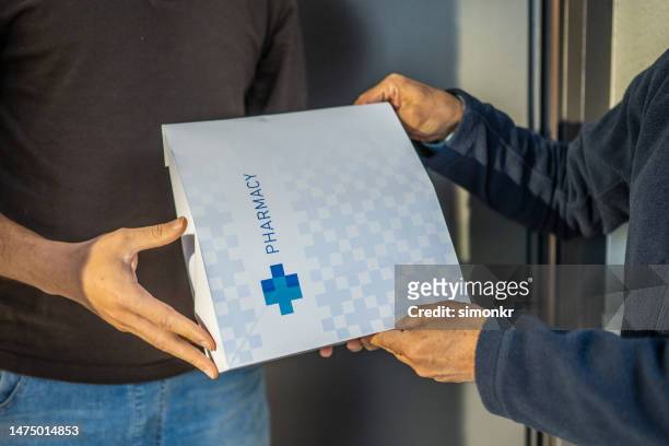 man delivering package to customer - prescription home delivery stock pictures, royalty-free photos & images