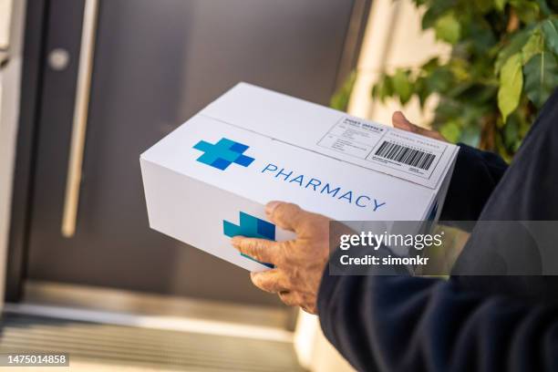 delivery person holding medicine box - prescription home delivery stock pictures, royalty-free photos & images