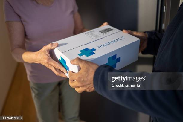 delivery person delivering medicine - prescription home delivery stock pictures, royalty-free photos & images