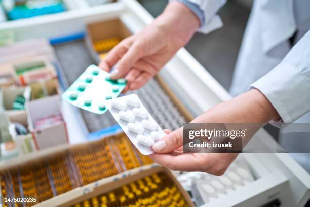 female pharmacist holding medicines - pharmaceutical stockfoto's en -beelden