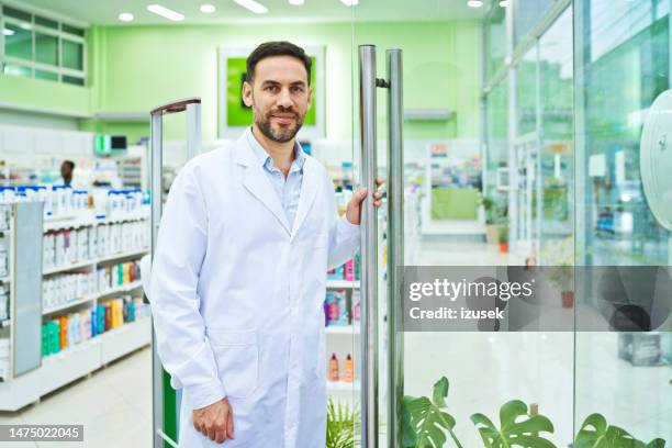 male pharmacist in pharmacy - glass entrance imagens e fotografias de stock