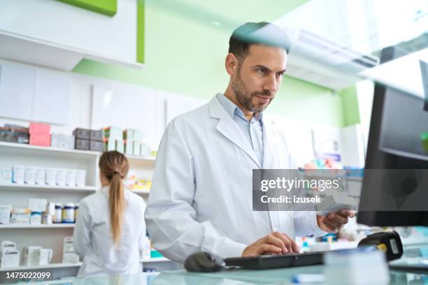 male pharmacist in pharmacy - pharmacist stock pictures, royalty-free photos & images