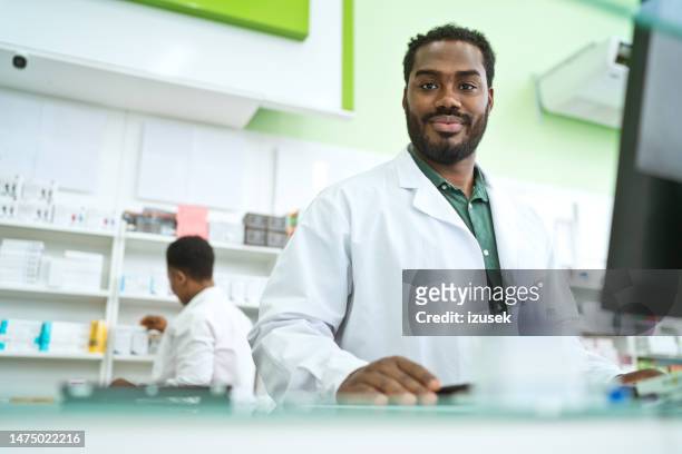 male pharmacist in pharmacy - portrait smiling stock pictures, royalty-free photos & images