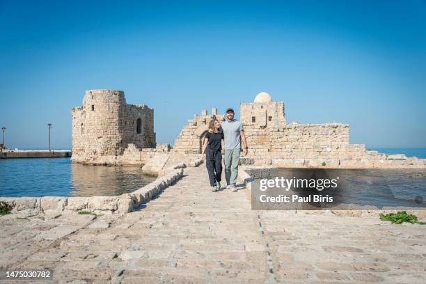 young couple visiting sea castle in sidon, lebanon. the main gate of the crusader castle in sidon, lebanon - beirut people stock pictures, royalty-free photos & images