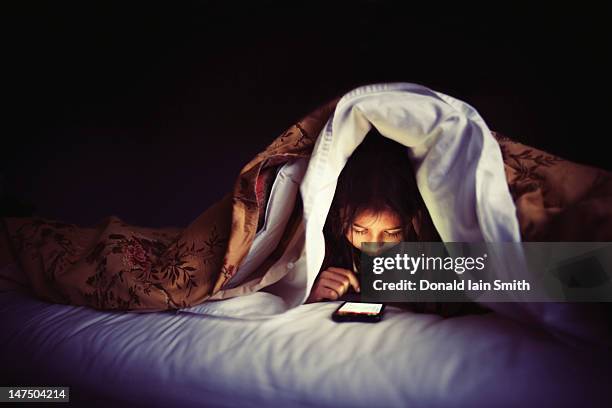 night time connection - child mobile phone stock-fotos und bilder