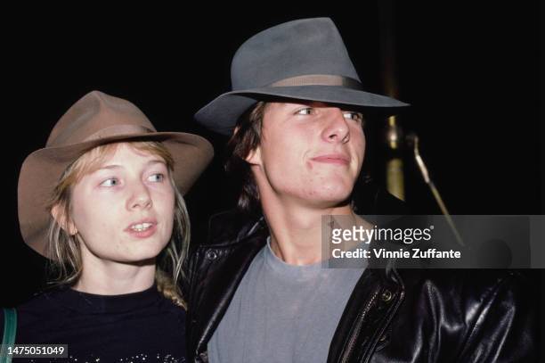 Rebecca DeMornay and Tom Cruise wearing fedora style hats, unspecified location, October 1983.
