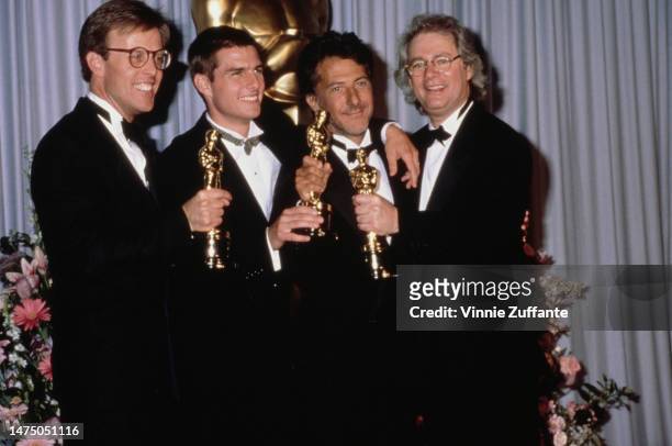Mark Johnson, Tom Cruise, Dustin Hoffman and Barry Levinson holding their Oscar statuettes for the film 'Rain Man', at the 61st Academy Awards held...