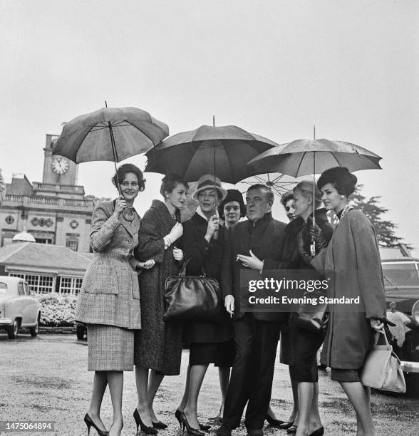 British designer Norman Hartnell arrives at the racecourse at Ascot racecourse in Berkshire with a group of his models for a fashion show, held in...