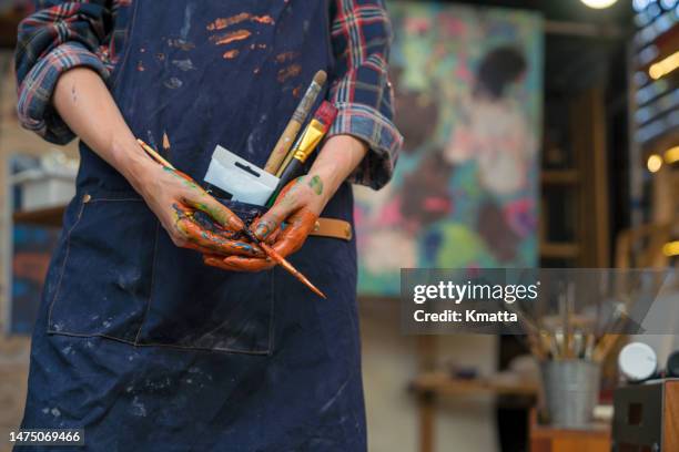 artist hand full of colorful paint holding paint brush. - darstellender künstler stock-fotos und bilder
