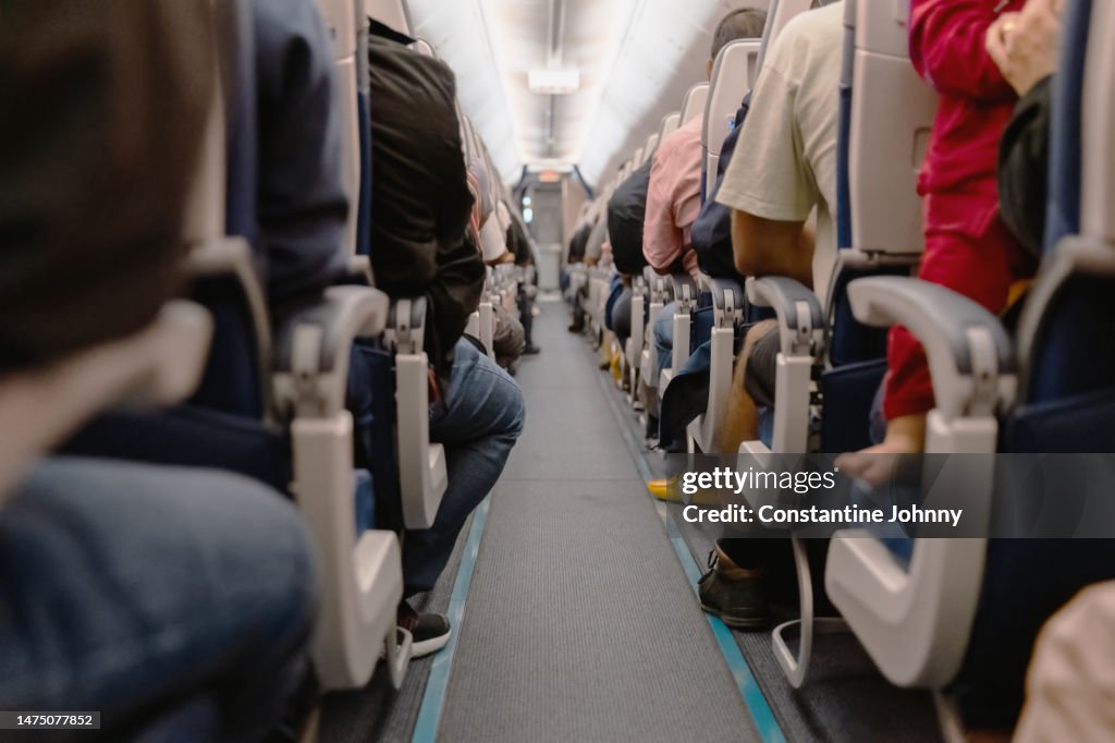 Airplane Aisle with View Of People Sitting on Their Seats