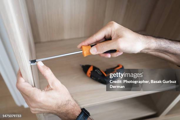 a man assembling a cabinet - bracket household fixture stock-fotos und bilder
