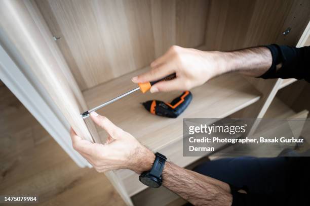 a man assembling a cabinet - building shelves stock pictures, royalty-free photos & images