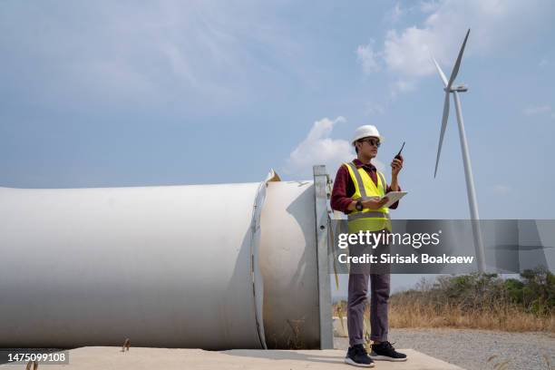 technician inspecting wind turbines with propellers and motors ready for installation - large construction site stock pictures, royalty-free photos & images