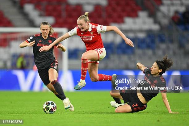 Frida Maanum of Arsenal jumps for the ball whilst under pressure from Klara Buehl and Saki Kumagai of FC Bayern München during the UEFA Women's...