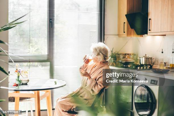senior woman with a cup of tea is resting at home. - hot older women fotografías e imágenes de stock