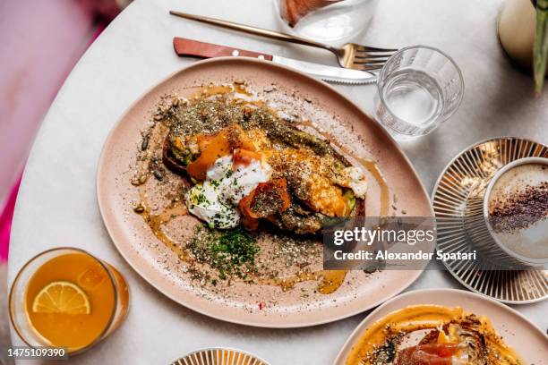 avocado toast with egg, yogurt and pumpkin for breakfast at a restaurant - lisbon food stock pictures, royalty-free photos & images