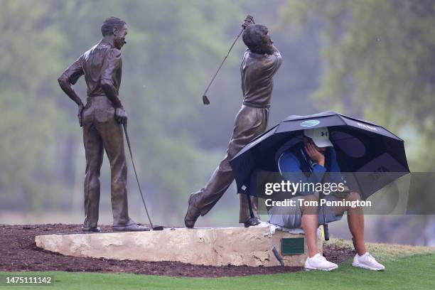 Caddie Michael Greller waits for Jordan Spieth of the United States to arrive to the putting green during a practice round ahead of the World Golf...