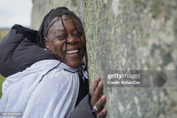 Woman embraces a megalith as Druids, Pagans and revellers gather at Stonehenge to mark the spring equinox on March 21, 2023 in Amesbury, England....