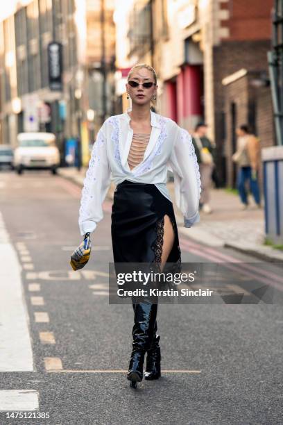 Betty Bachz wears a Christopher Kane shirt and skirt, Tamara Mellon boots, Moy Atelier sunglasses and a Vivienne Westwood bag outside the Christopher...