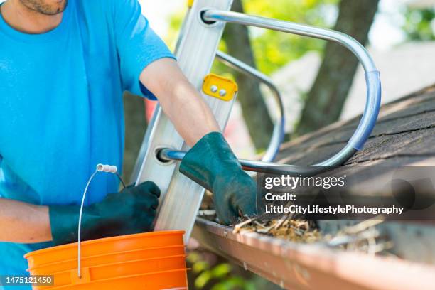 maintaining the house includes eavestrough cleaning - calheta imagens e fotografias de stock