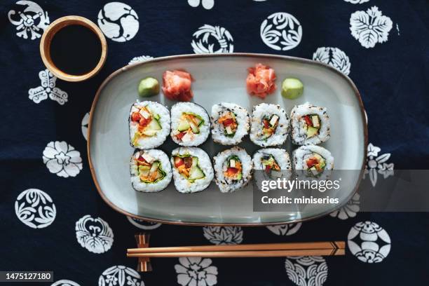tischansicht von sushi-rollen auf dem teller mit sojasauce und essstäbchen - fresh wasabi stock-fotos und bilder