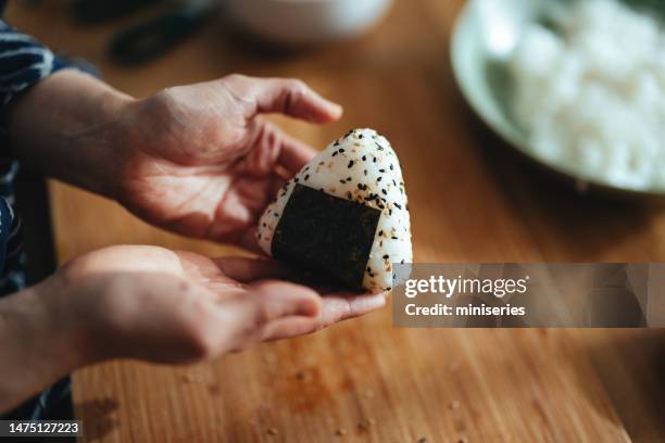 foto de cerca de manos de mujer preparando onigiri en casa - bola de arroz fotografías e imágenes de stock