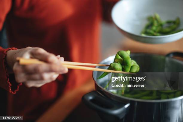 close up photo of woman hands cooking edamame at home - edamame stock pictures, royalty-free photos & images