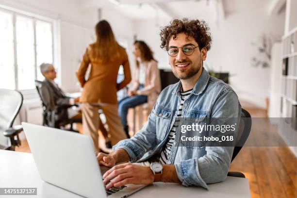 portrait of young handsome businessman in the modern office - estudante adulto imagens e fotografias de stock