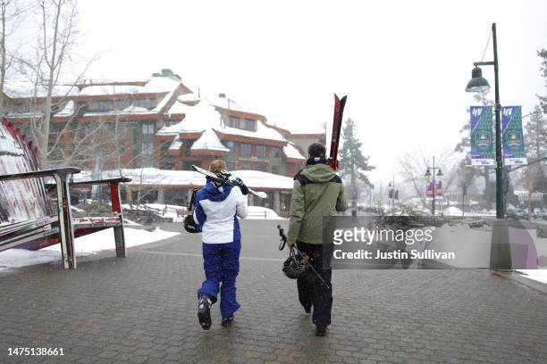 People carry skis as they walk towards a resort on March 21, 2023 in South Lake Tahoe, California. As a 12th atmospheric river hits California, the...
