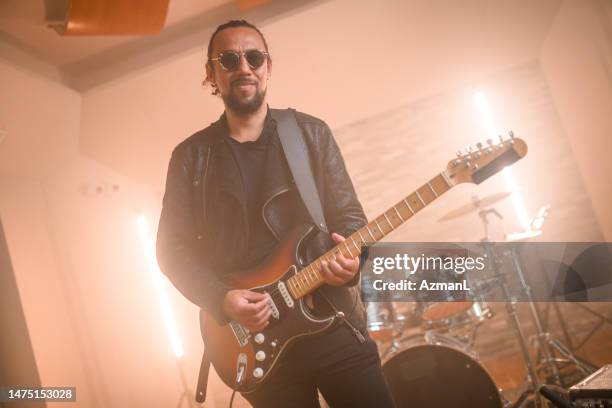 hispanic guitarist recording music in recording studio - bass guitar stock pictures, royalty-free photos & images