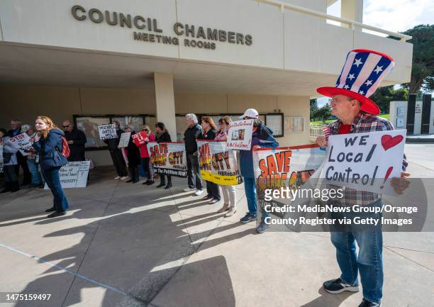 Huntington Beach, CA Russell Neal of Huntington Beach, right, along with others hold signs in support of speakers Huntington Beach Mayor Tony...
